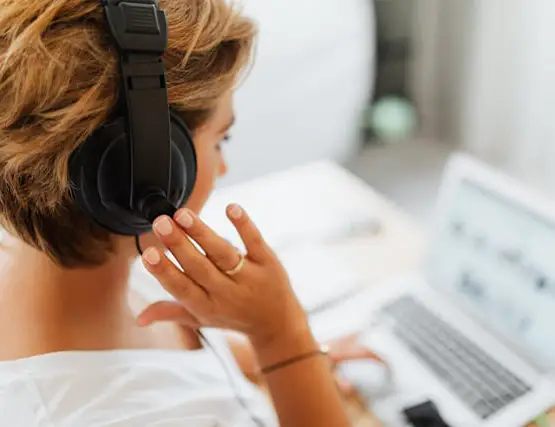 Person with headphones using laptop computer while working or studying from home